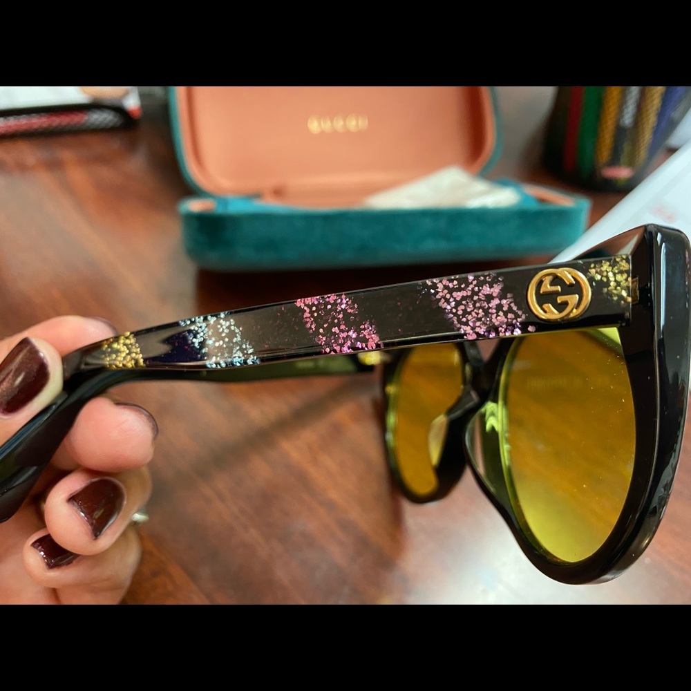 Gucci Contemporary Cateye Sunglasses that are accented with glitter detailing.